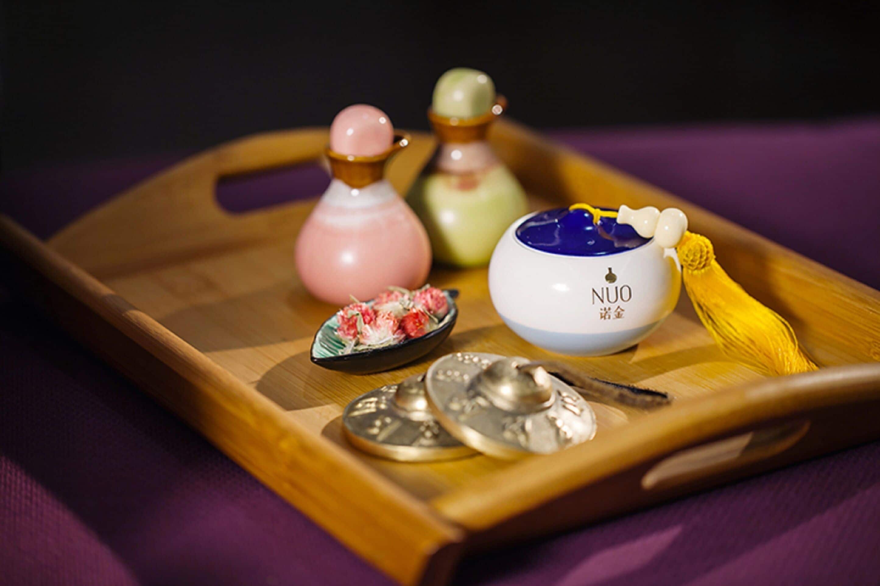A tray with various containers and utensils, including a bowl labeled "NUO" and a small dish with food.