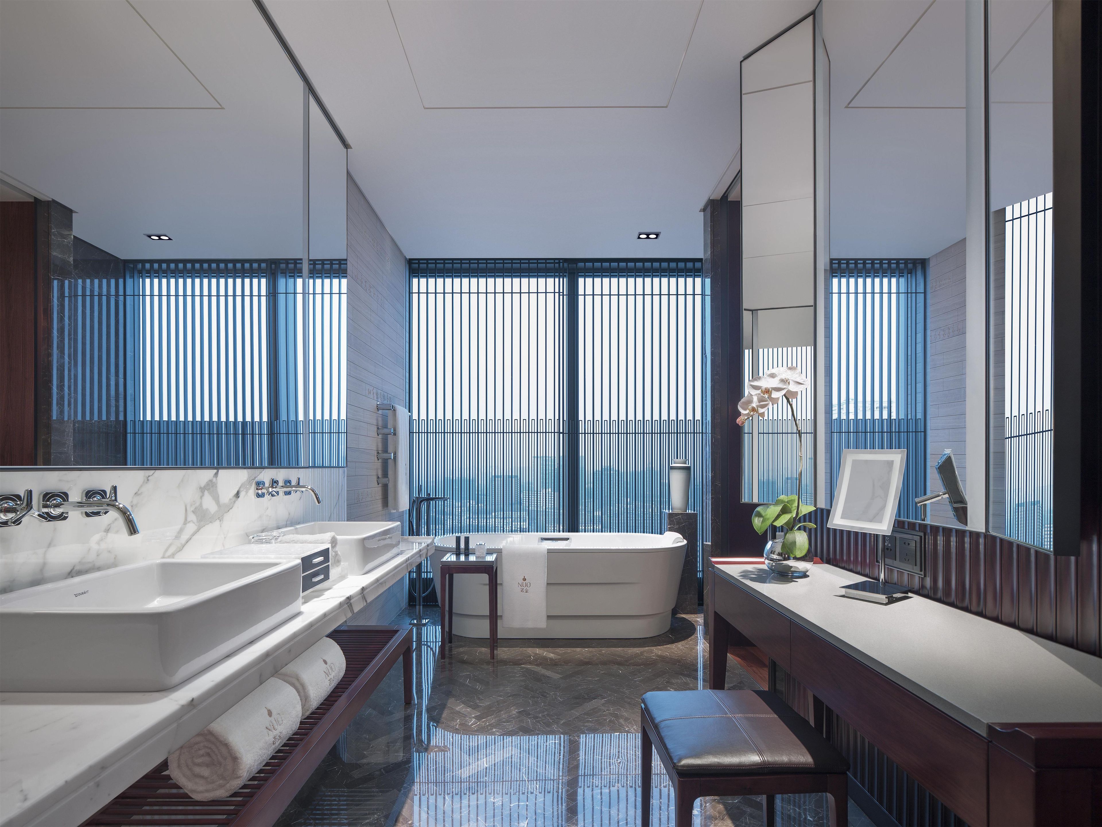 Une salle de bain moderne dotée d’une grande baignoire, d’une douche séparée et d’un meuble-lavabo avec un miroir.