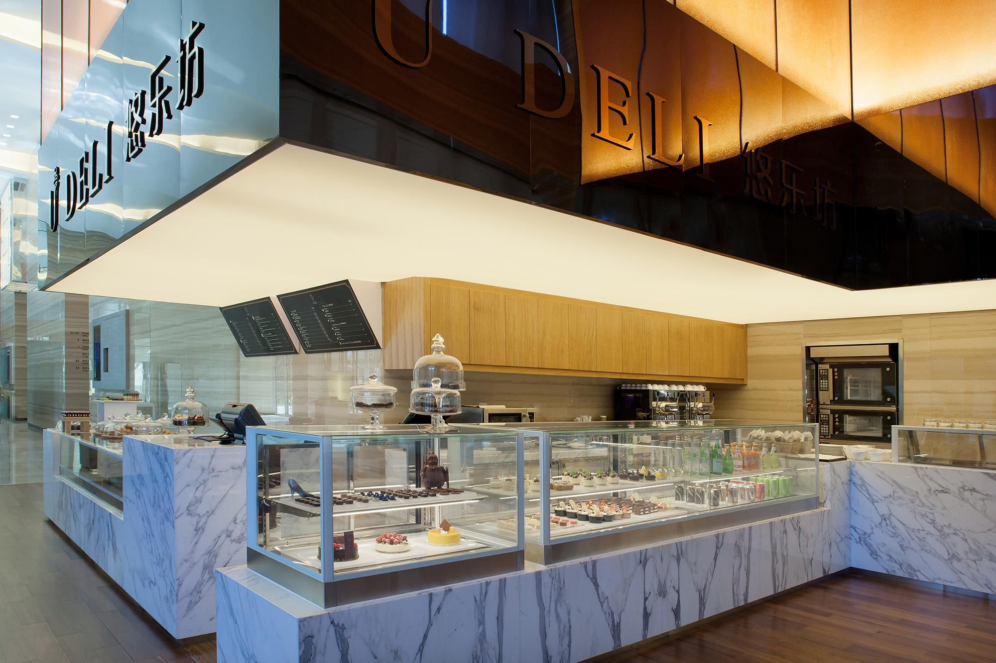 A dessert display with a marble counter and a wooden ceiling.
