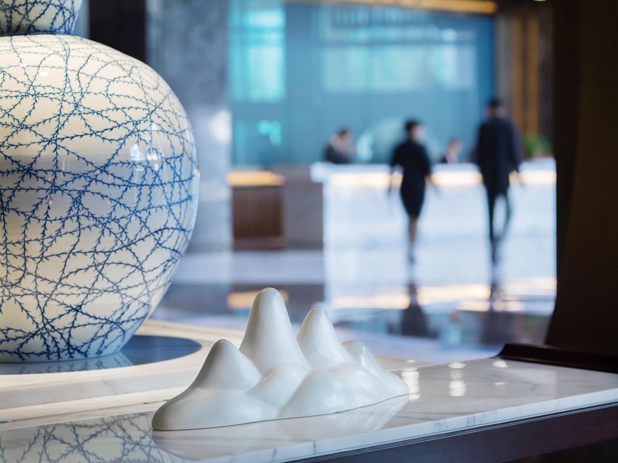 A reception area with a large decorative vase and a white sculpture on display.