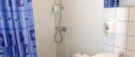 A bathroom with a shower, toilet, and sink.