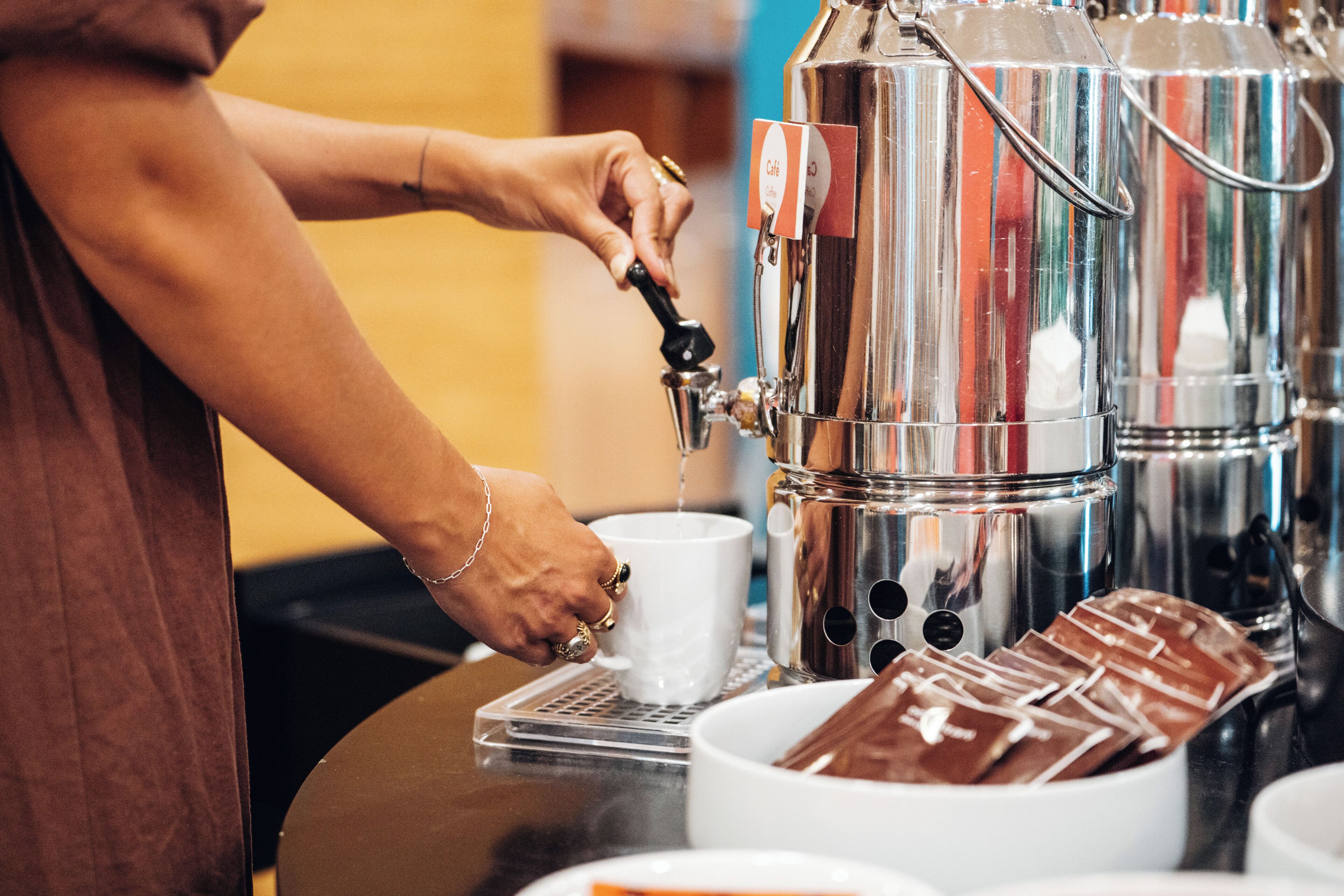 A barista preparing a drink at a coffee machine.