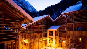 Une cabane en bois dotée d’une tour centrale, de plusieurs balcons et dont l’extérieur est recouvert de neige.