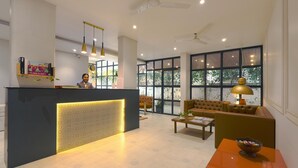 A modern reception area with a reception desk, seating area, and large windows providing natural light.