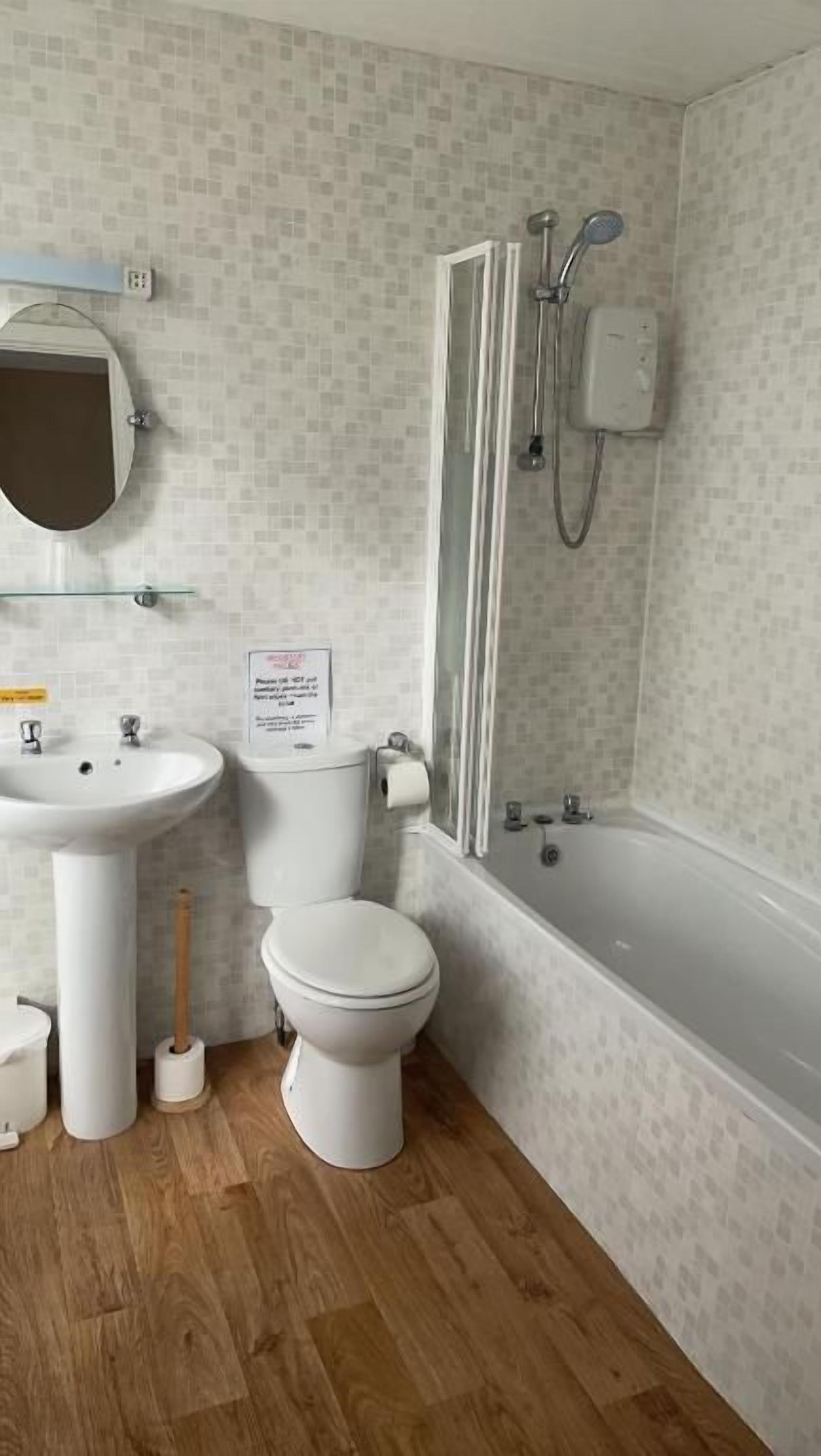 Een badkamer met een witte wastafel, toilet en bad.