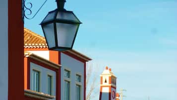 Un edificio con fachada roja y blanca, una torre de campanas y un balcón.