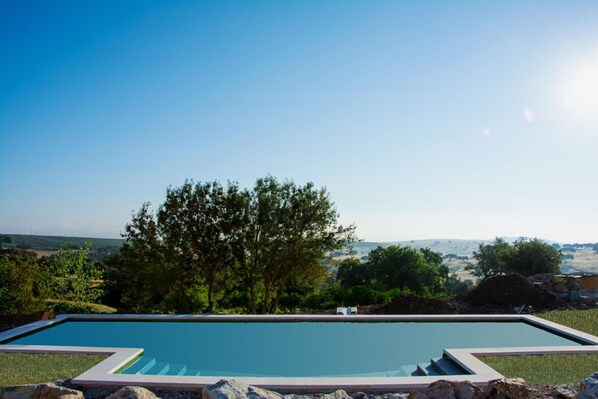 室外游泳池，池畔遮阳伞，日光浴躺椅