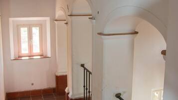 Eine Treppe mit Holzboden und weißen Wänden, die zu einer oberen Etage führt.