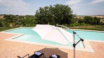 Piscine extérieure, parasols de plage, chaises longues