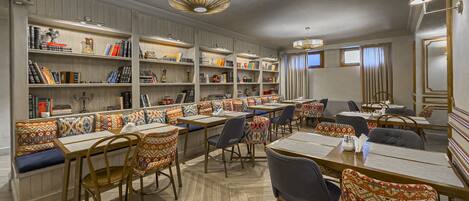 A library with bookshelves, seating, and tables.