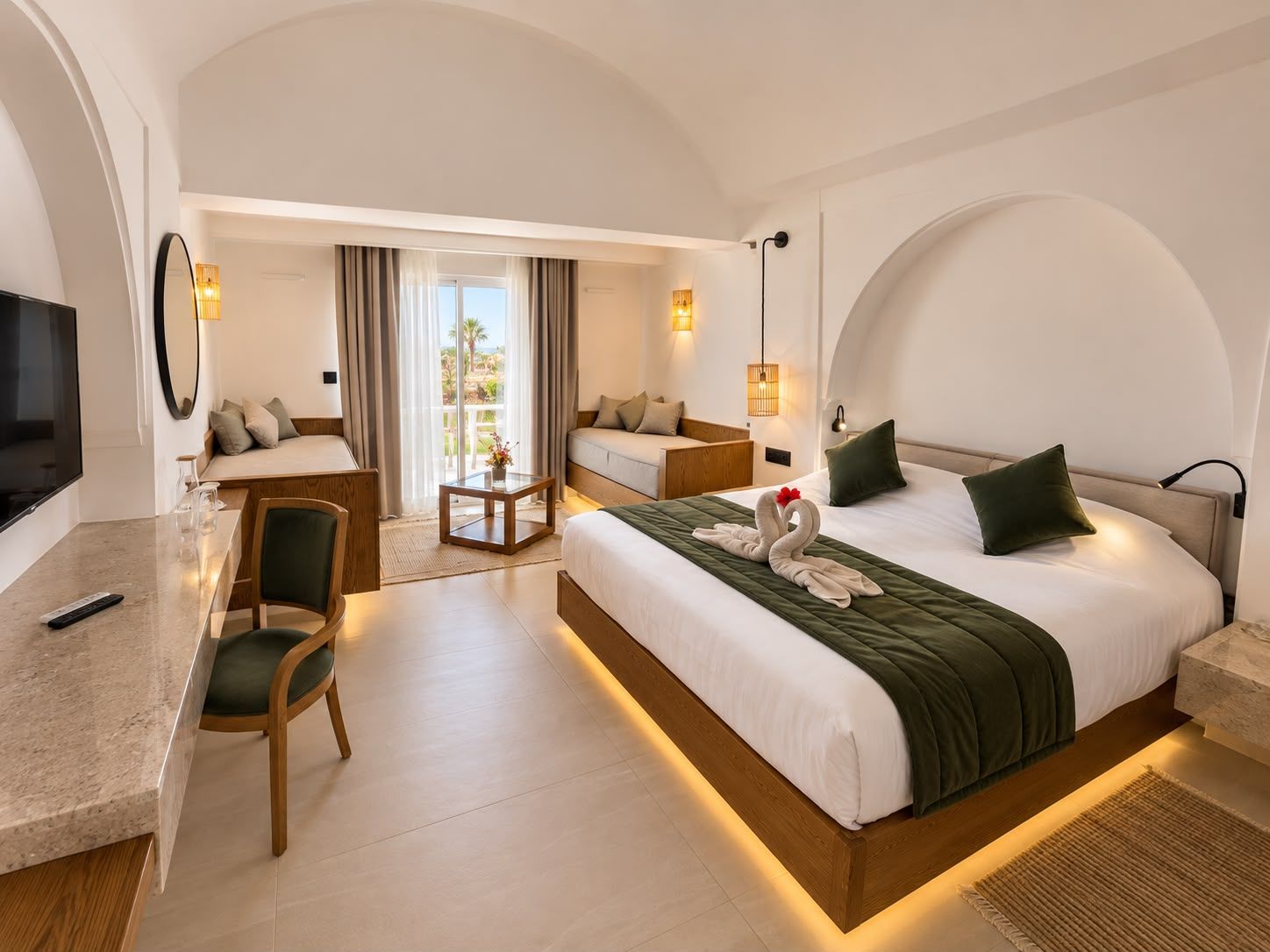 Une chambre d’hôtel avec un grand lit, un bureau avec une chaise, une télévision et un balcon avec des rideaux.