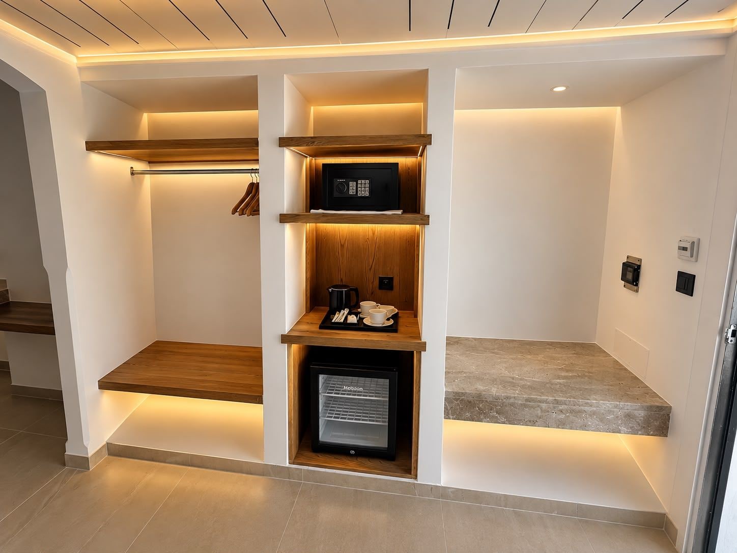 A modern kitchen with built-in appliances, wooden shelves, and a coffee station.