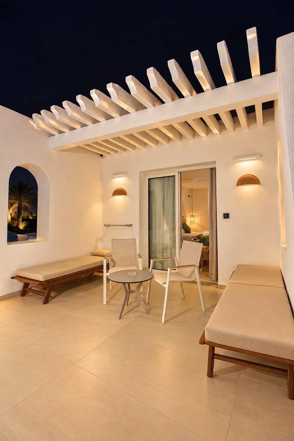 A modern outdoor seating area with a pergola, cushioned benches, and a table.