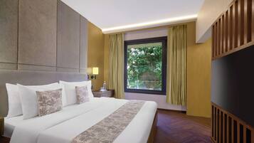 Habitación de hotel con una cama grande, una mesita de noche, una ventana con cortinas y vistas a zonas verdes.