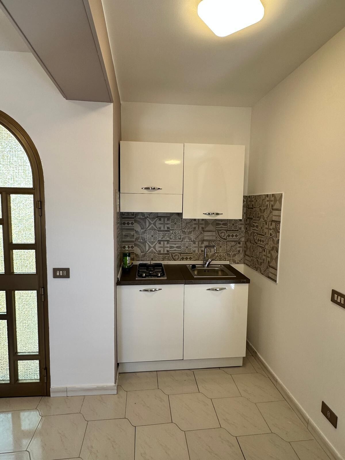 A kitchen with white cabinets, a gas stove, and a sink.