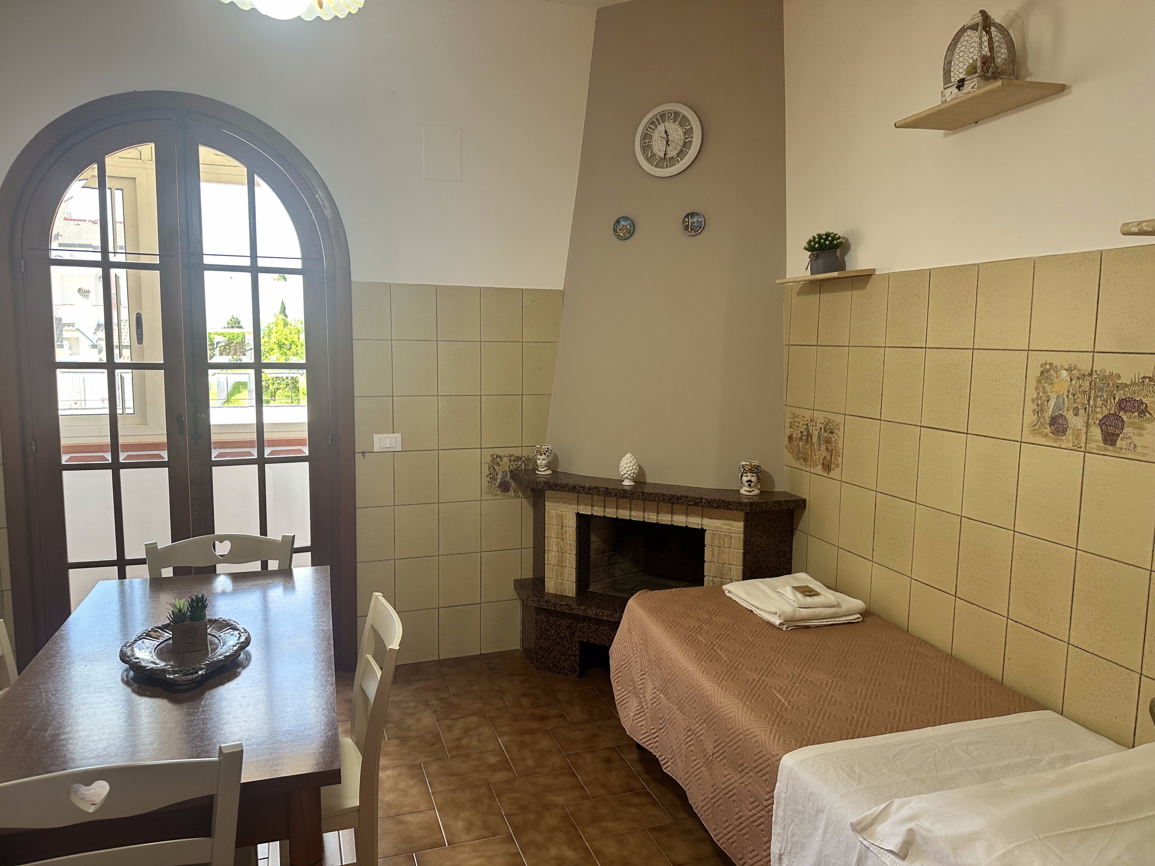 Una habitación con una mesa de comedor, sillas, chimenea, cama y vistas por una ventana.