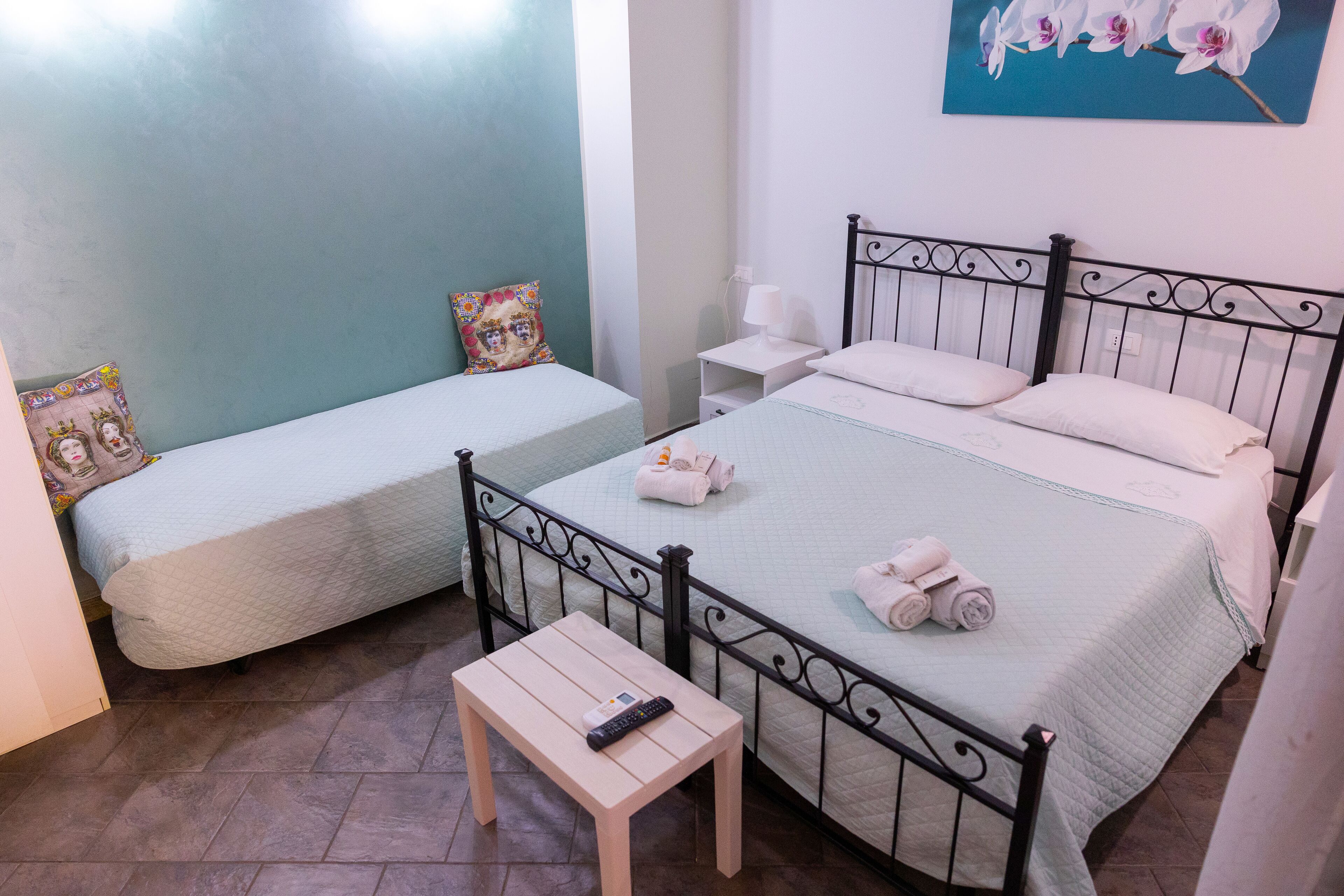 Un dormitorio con dos camas, una mesita de noche y un mueble auxiliar.