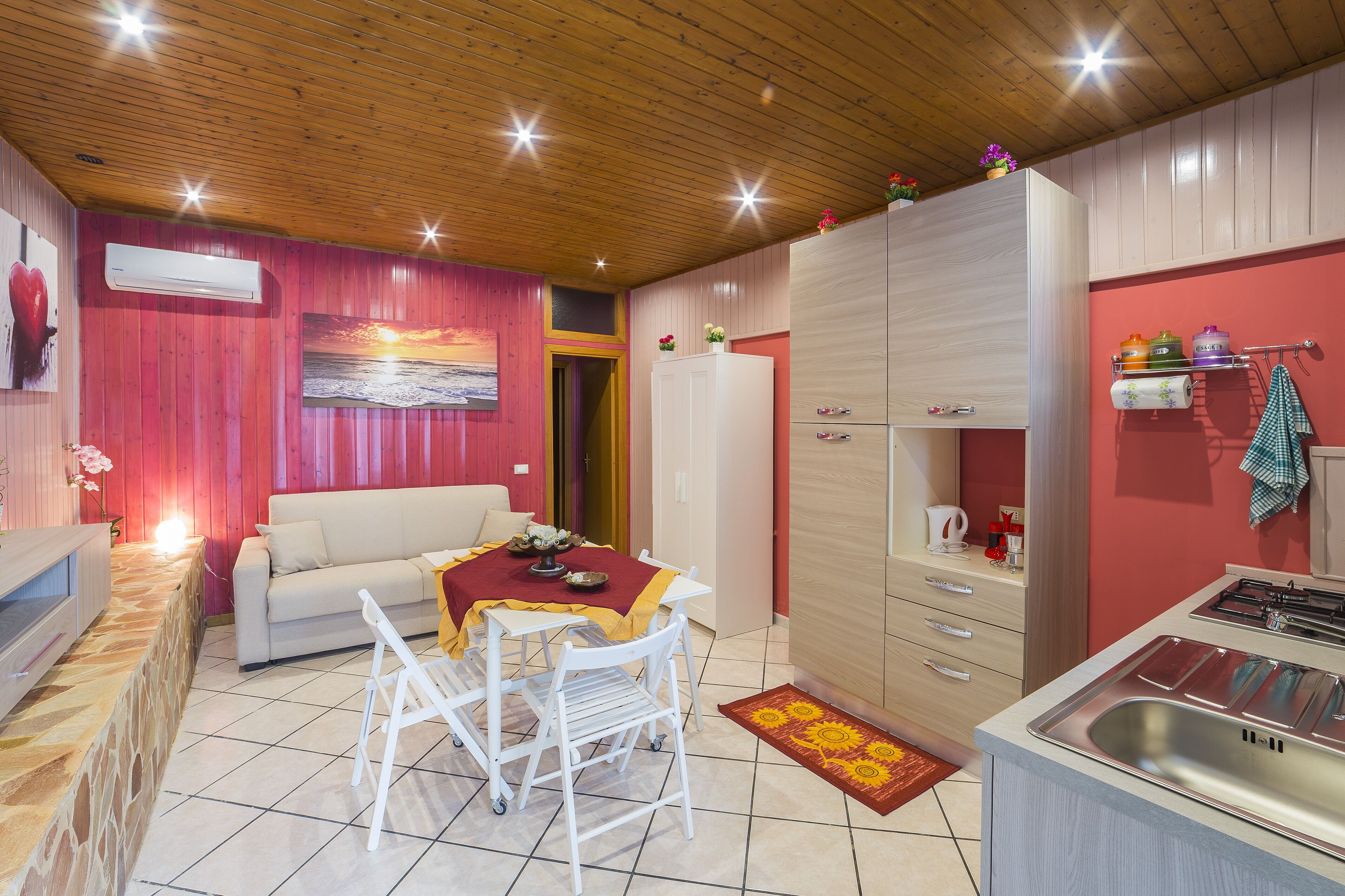 Una cocina acogedora con comedor, un refrigerador blanco y techo de madera.