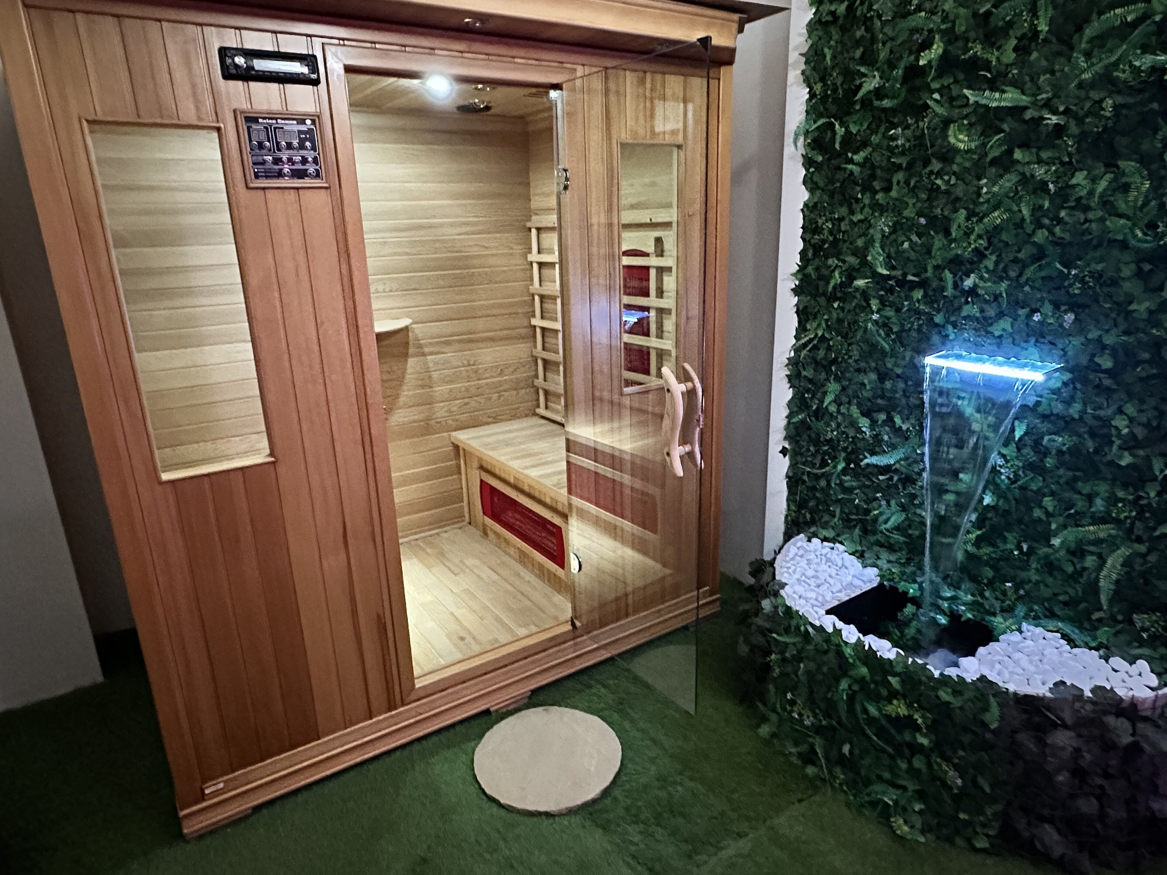 Un sauna avec des murs en bois, un banc et une petite étagère.