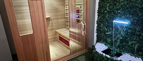 Un sauna avec des murs en bois, un banc et une petite étagère.
