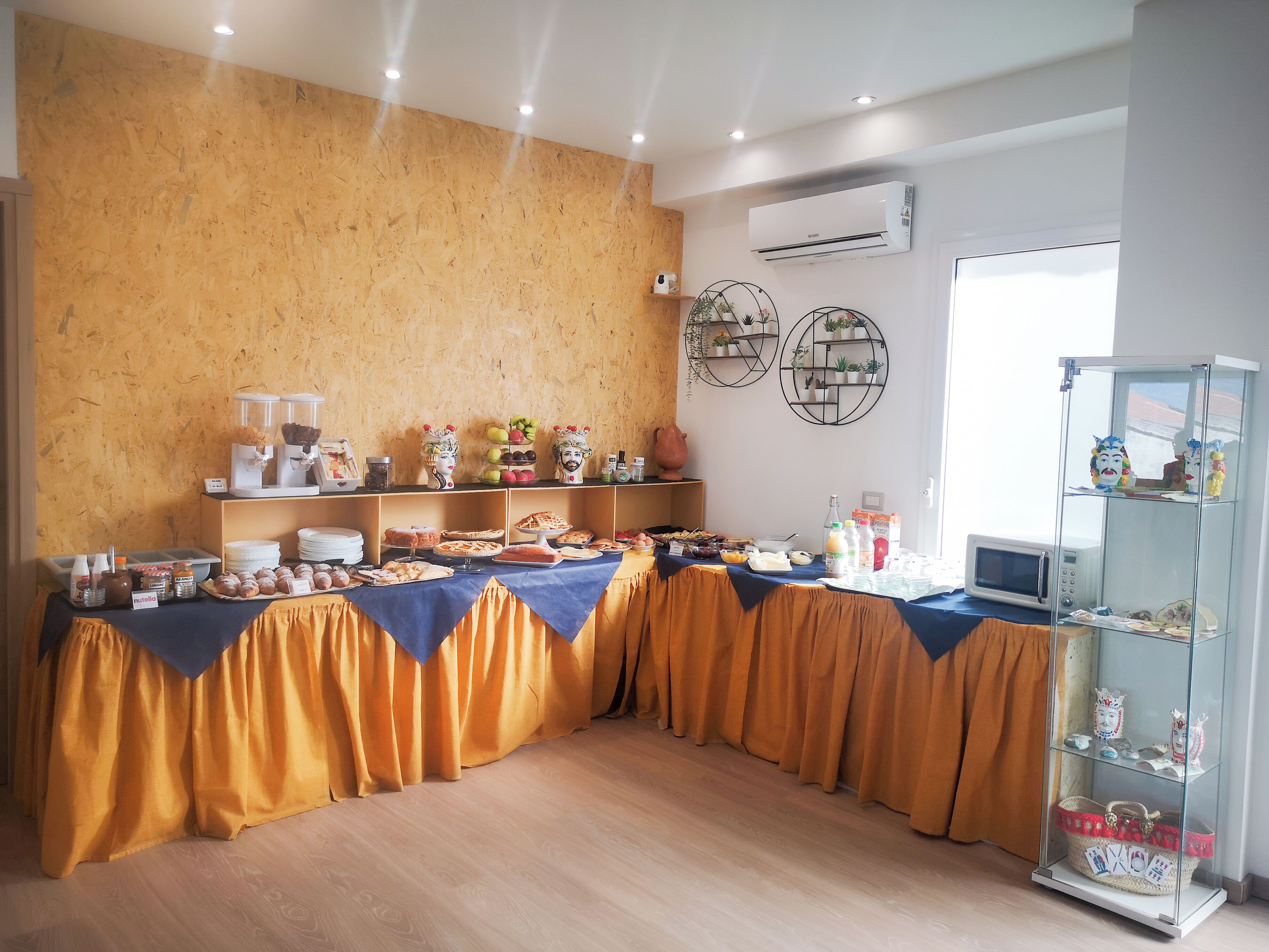A buffet setup with various food items and a glass display case with decorative items.