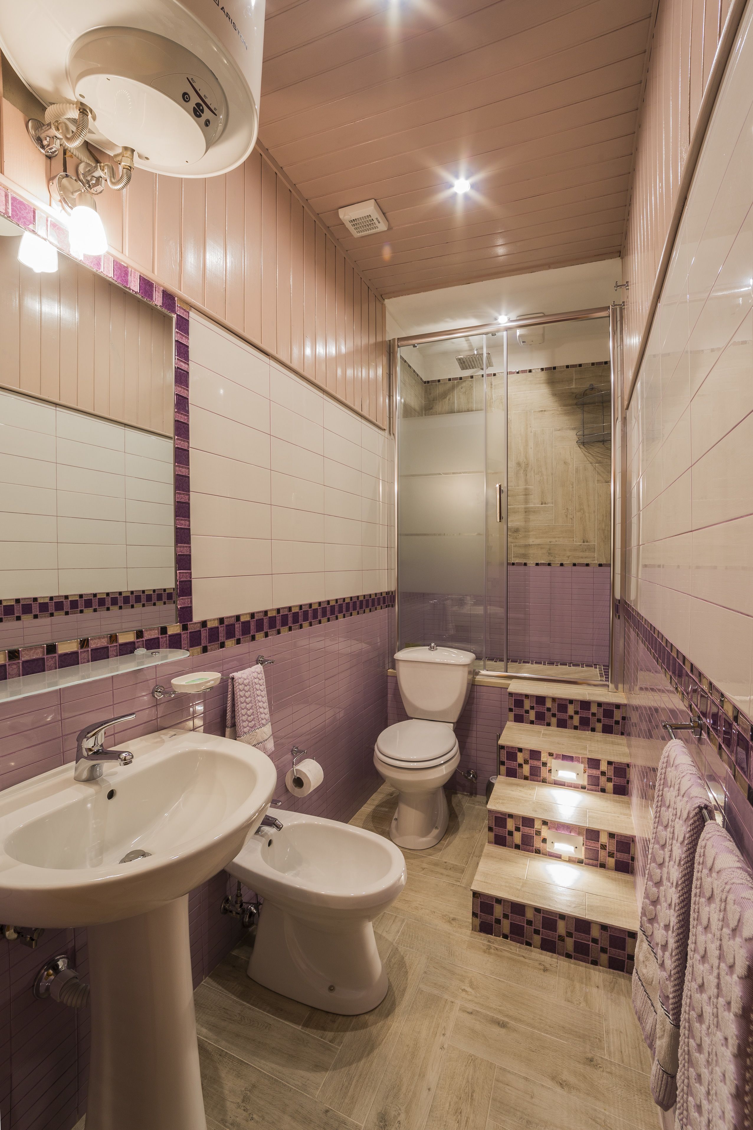 Une salle de bain équipée d’un lavabo, d’un bidet, de toilettes et d’un espace douche.
