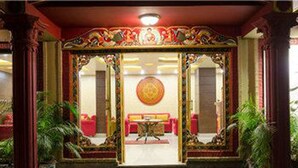 Un interior tradicional con decoraciones elaboradas, una mesa redonda central y asientos rojos.