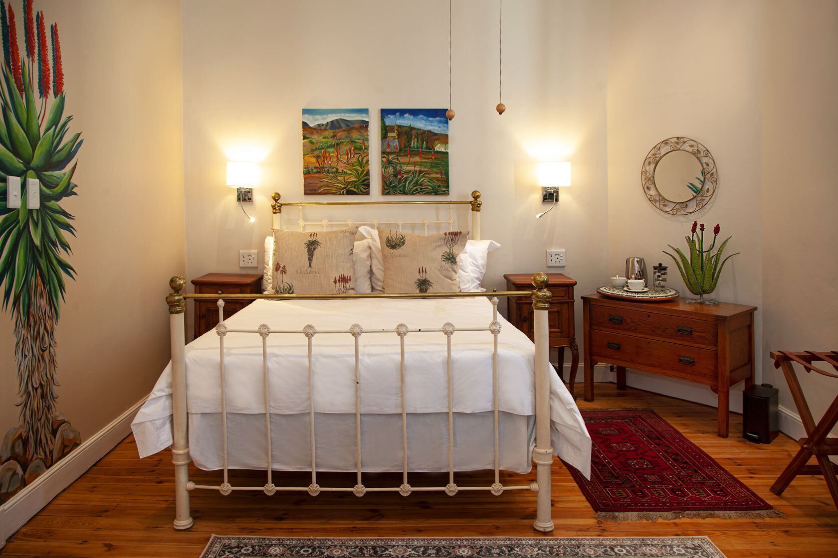 Un dormitorio con cama, lámparas de noche, mesita de noche, cómoda, espejo y una planta grande.