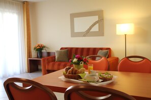 Enjoy a warm breakfast at the dining table, set with a tray of pastries, coffee, and juice.