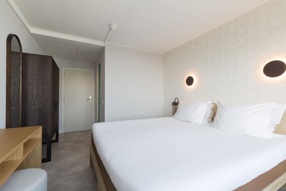 Ein Schlafzimmer mit einem großen Bett, einem Holztisch und einem Kleiderschrank.