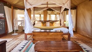 A tent-style room with a canopy bed, wooden furniture, and a fan. - Elephant Bedroom Camp (Samburu)