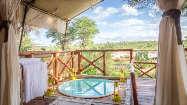 A wooden deck with a circular hot tub, surrounded by a wooden railing, and a view of a natural landscape. - Elephant Bedroom Camp (Samburu)