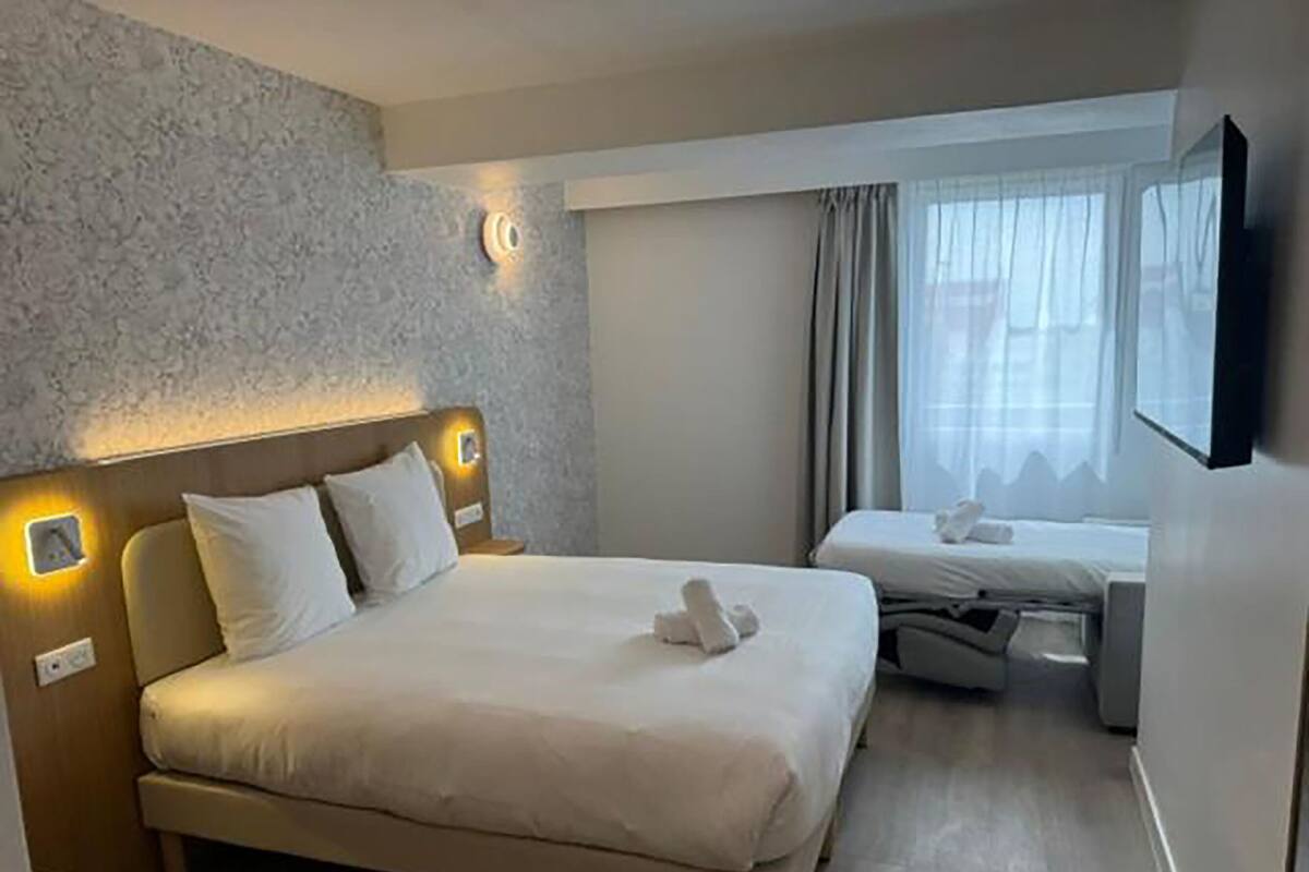 Comfort driepersoonskamer | Een kluis op de kamer, een bureau, geluiddichte muren, gratis wifi
