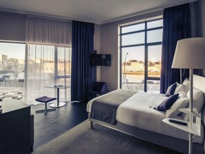 A modern hotel room with a large bed, a desk, a chair, and a TV. - Hotel Mercure Cherbourg Centre Port (Cherbourg-en-Cotentin)