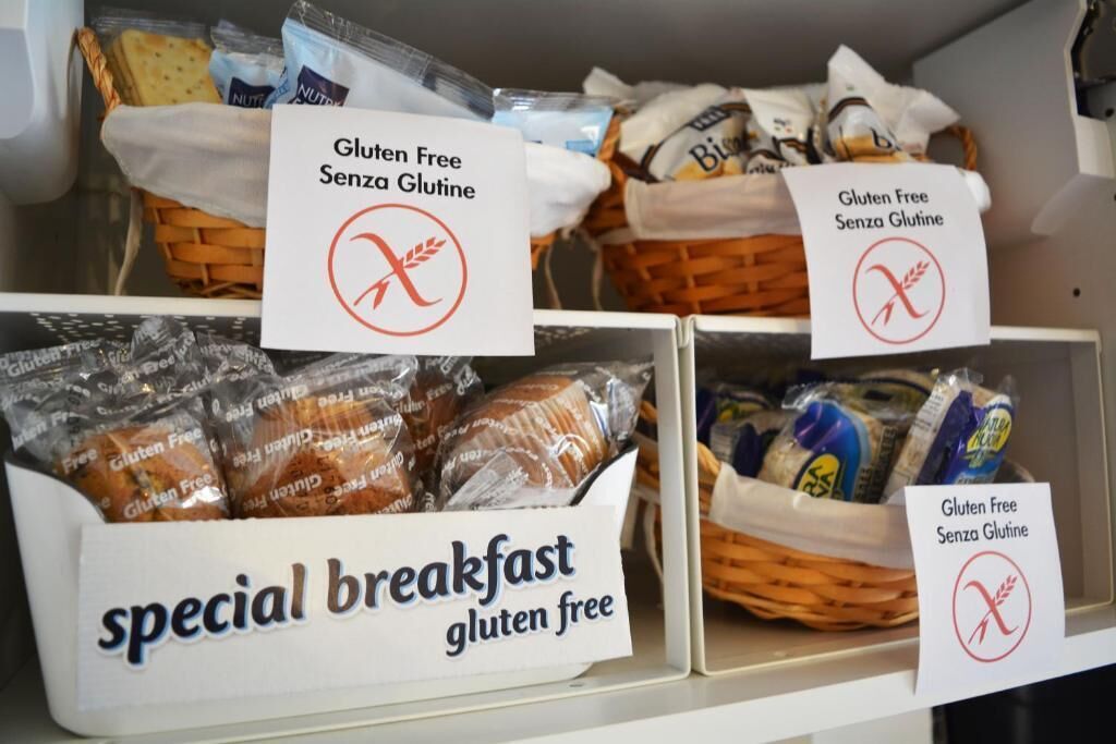 A gluten-free section in a store with labeled boxes and baskets of bread and other products.
