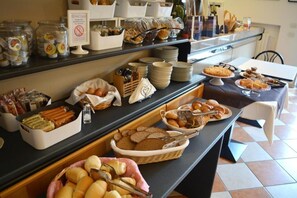 A buffet with various food items and utensils. - Villa Chiara (Lazise)