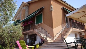 Ein zweistöckiges Gebäude mit Balkon, Außenbereich und einer Treppe.
