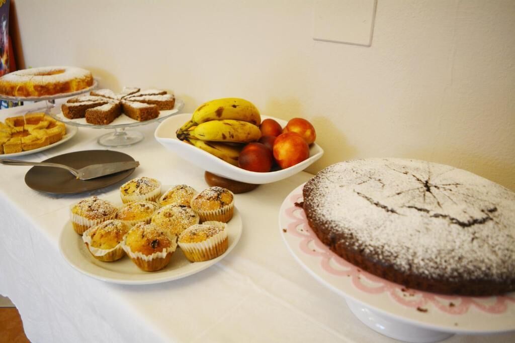 Ein Buffet mit verschiedenen Desserts, darunter Kuchen, Muffins und Obst.