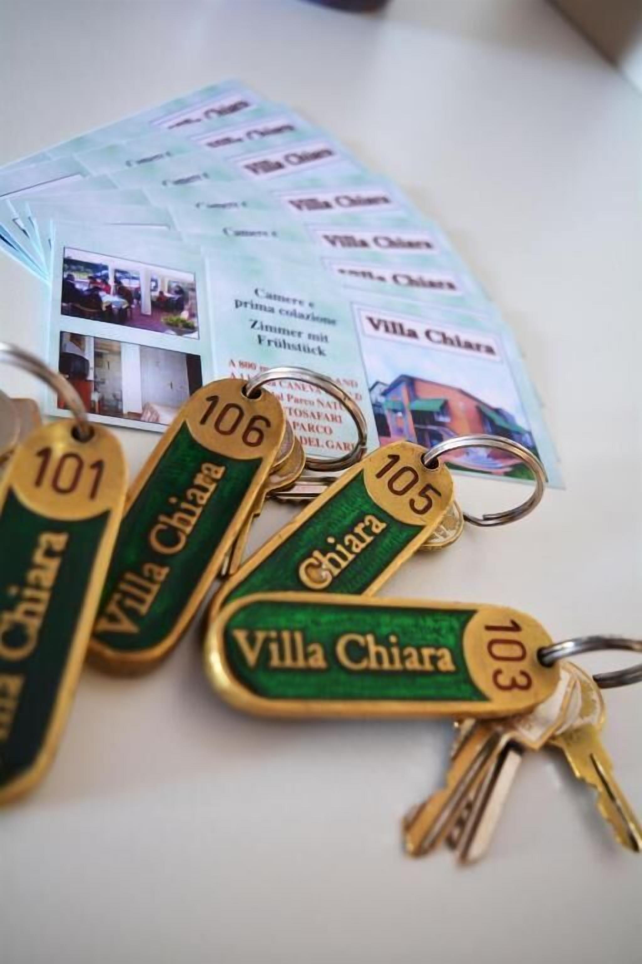 Llaveros con la inscripción "Villa Chiara" y números de habitación.