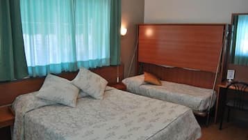 A room with two beds, a desk, and a chair.
