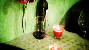 A table with a bottle of wine, two glasses, and two lit candles. - Claudia House Roma Termini (Rome)