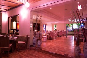 A restaurant with a glass wall, wooden flooring, and modern decor. - Bidwood Suite Hotel (Nairobi)