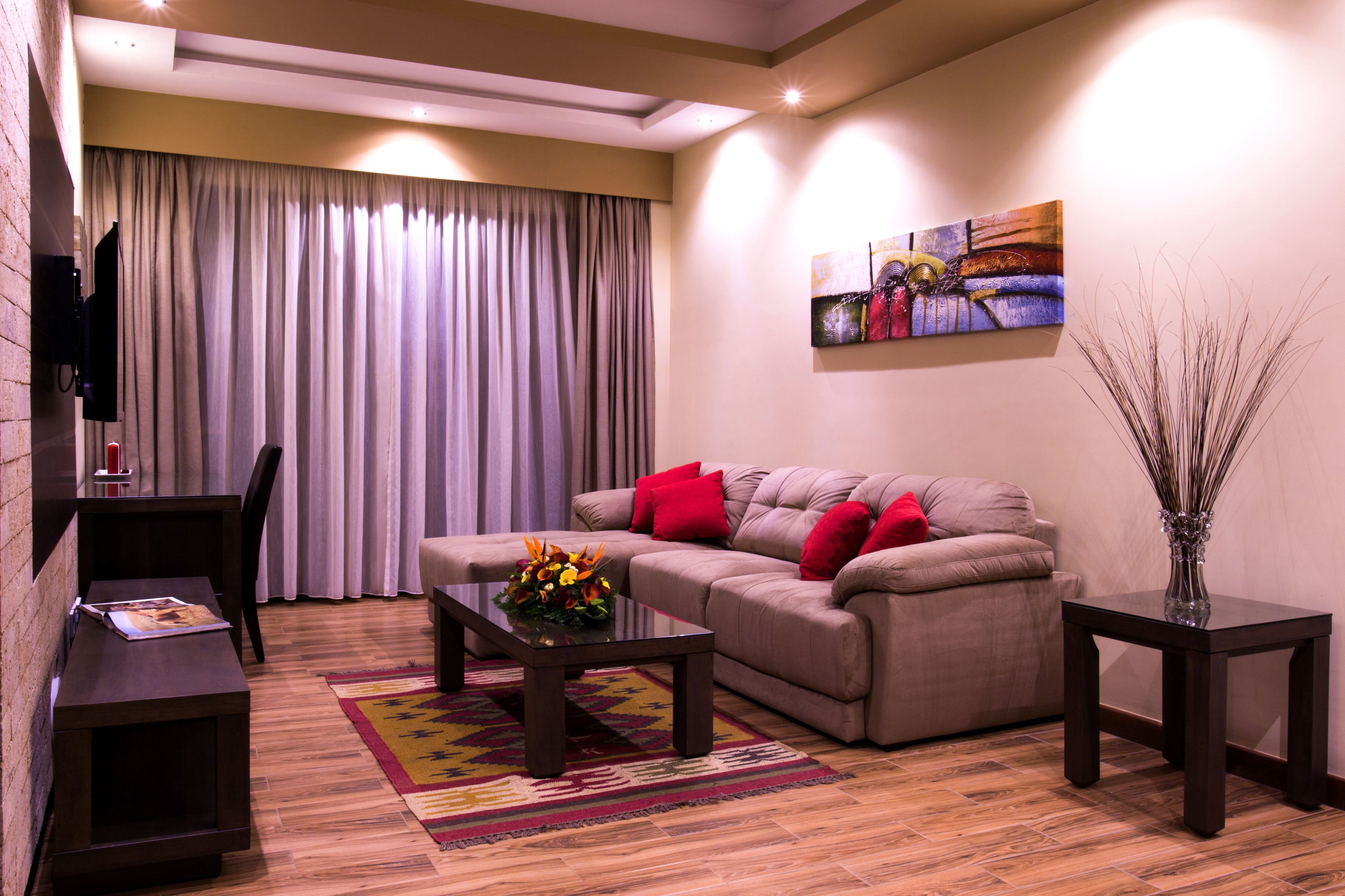 Una sala de estar con sofá, mesa de centro y televisor de pantalla plana.