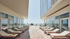 Terraza con sillones de descanso y vista a la playa.