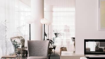 A modern living room with a grey armchair, a round coffee table, and a television.