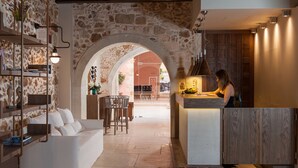 Eine moderne Küche mit einem Steingewölbe, einer Bar und einer Sitzecke mit einer Couch und Sesseln.