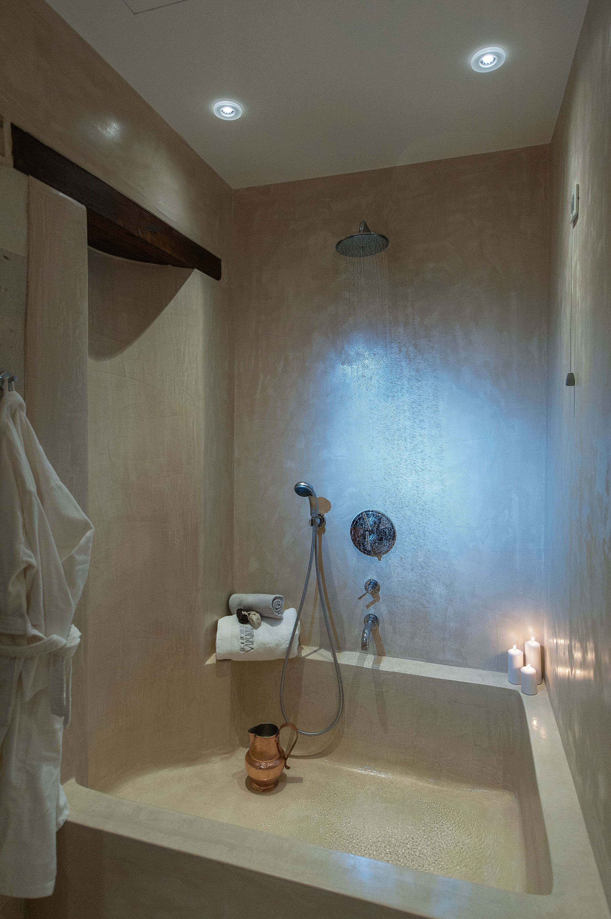 A modern bathroom with a bathtub, shower, and a towel rack.