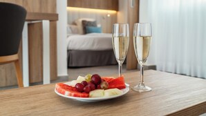 A wooden table with a plate of fruit and two glasses of champagne in a hotel room. - LABRANDA Alyssa Suite Hotel (Yaiza)