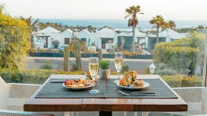 A table set with two plates of food, two glasses of champagne, and a small potted plant. - LABRANDA Alyssa Suite Hotel (Yaiza)