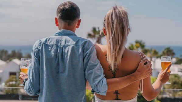 A couple standing on a balcony with drinks, overlooking a scenic view. - LABRANDA Alyssa Suite Hotel (Yaiza)